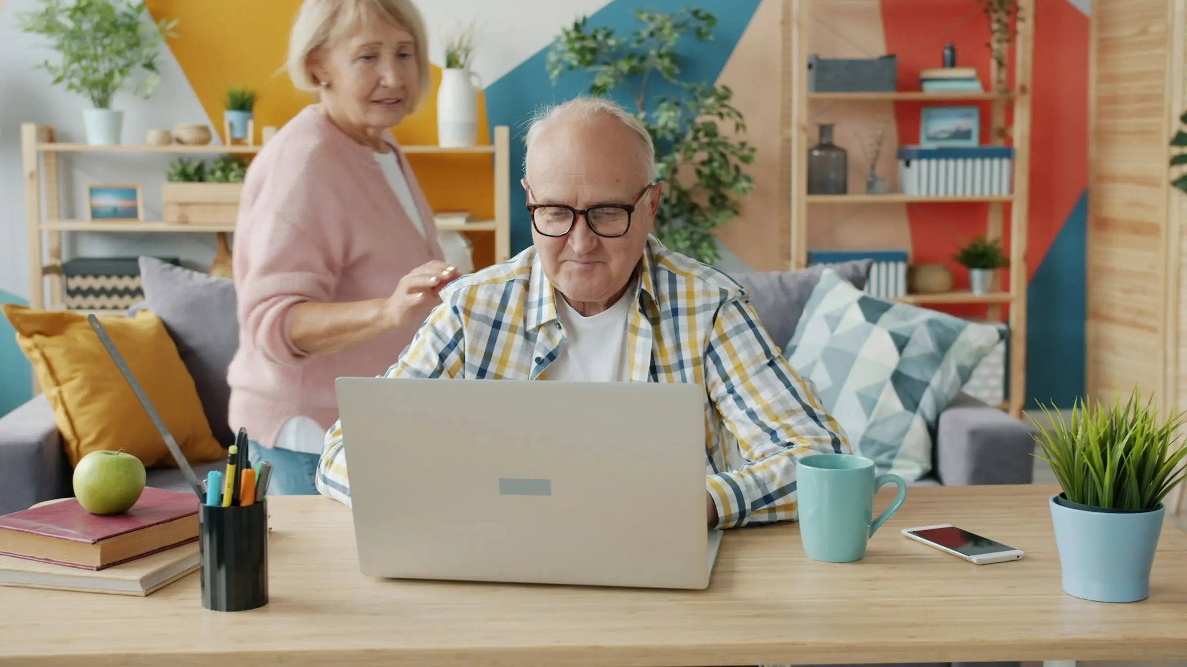 Zwei ältere Menschen sitzen gemeinsam vor einem Laptop